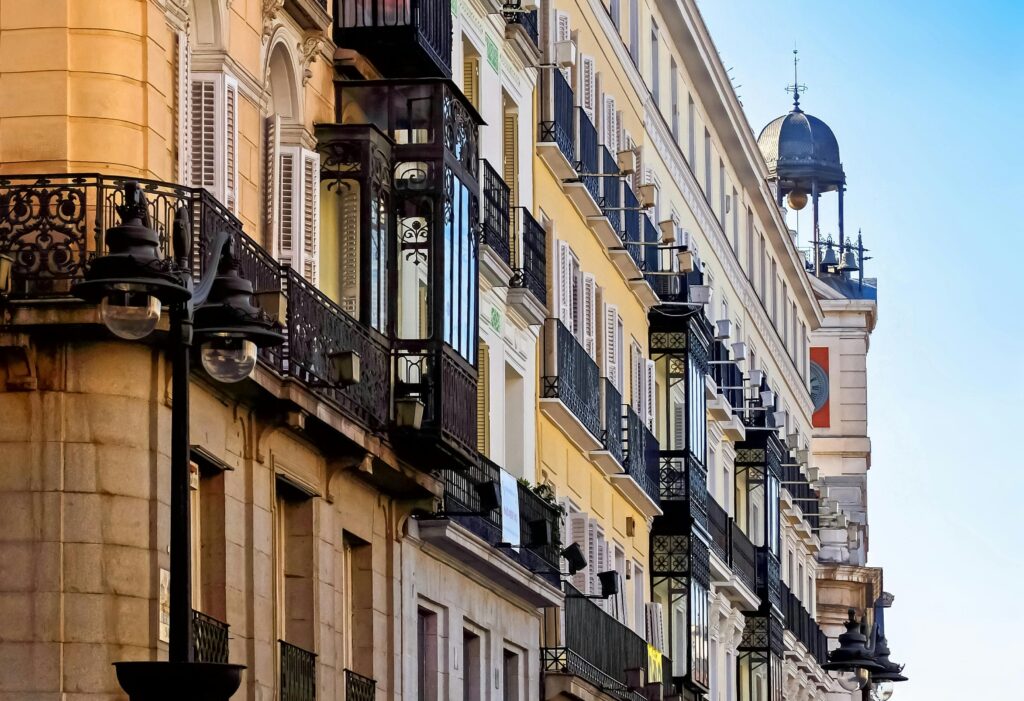 Elegant historic buildings and ornate balconies in a vibrant Madrid street scene.